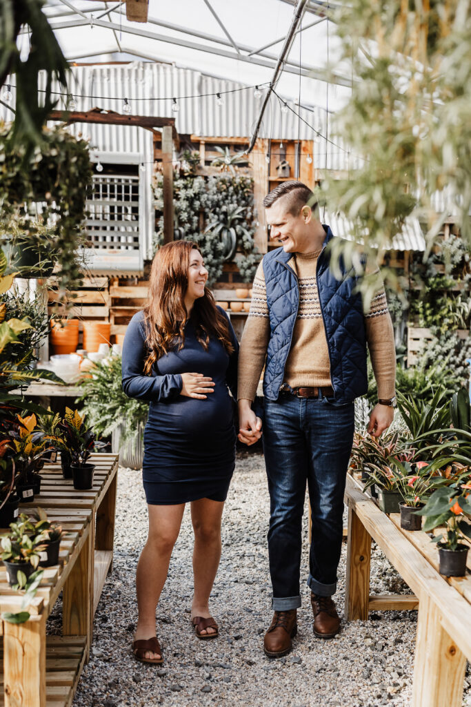 Husband and expecting wife walking through greenhouse for a Harrisburg, PA date night 