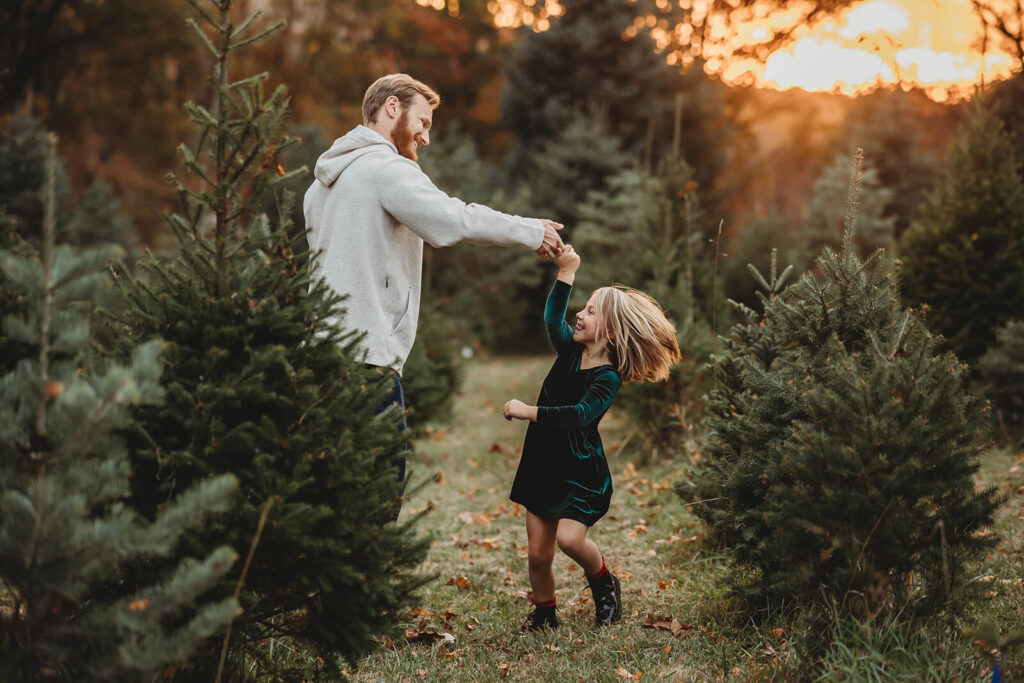 Dad twirling daughter at a Christmas Tree Farm around Harrisburg 