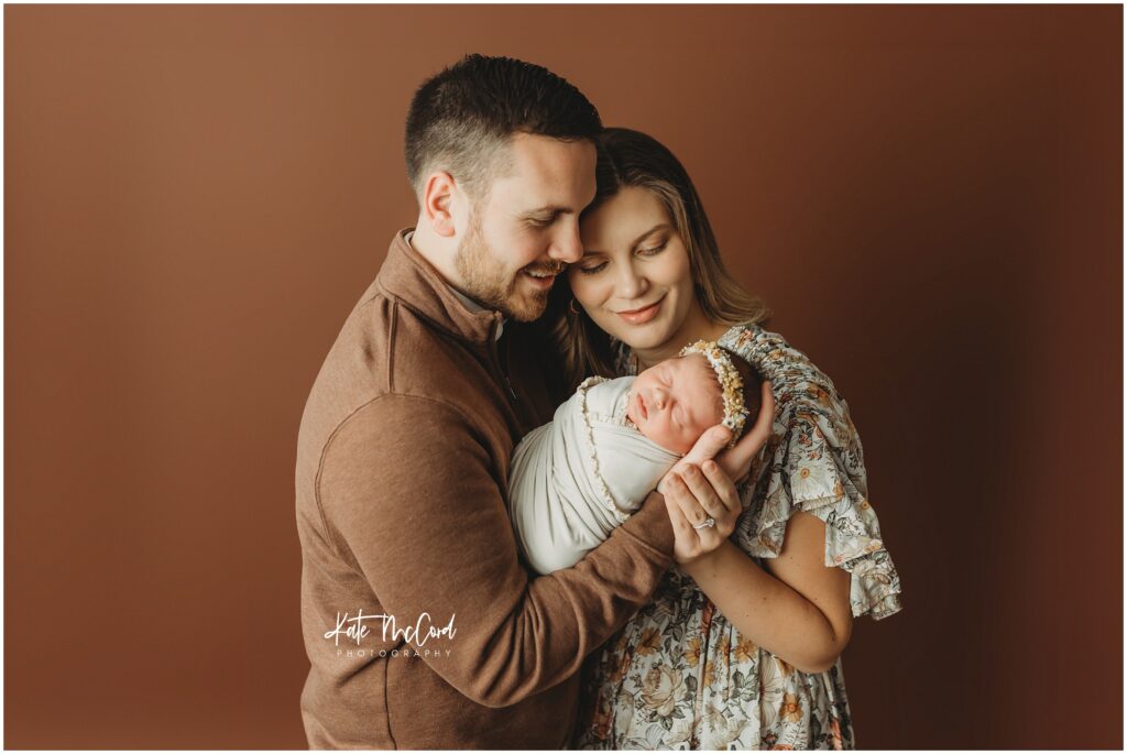 Mom and dad snuggled with their newborn baby girl during her york newborn session