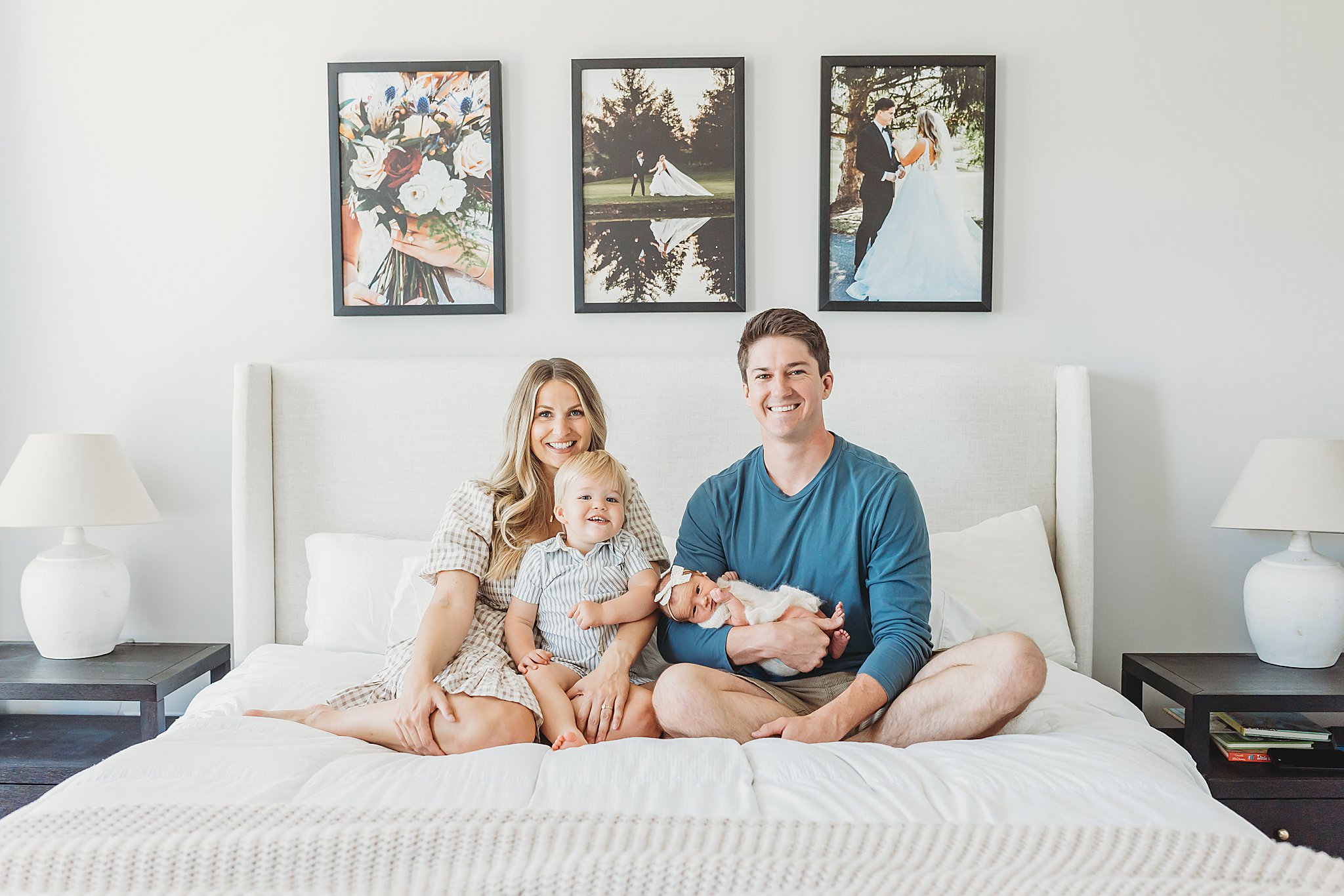 A newly minted family of four poses on their bed in their Mechanicsburg home with their toddler son and newborn baby girl