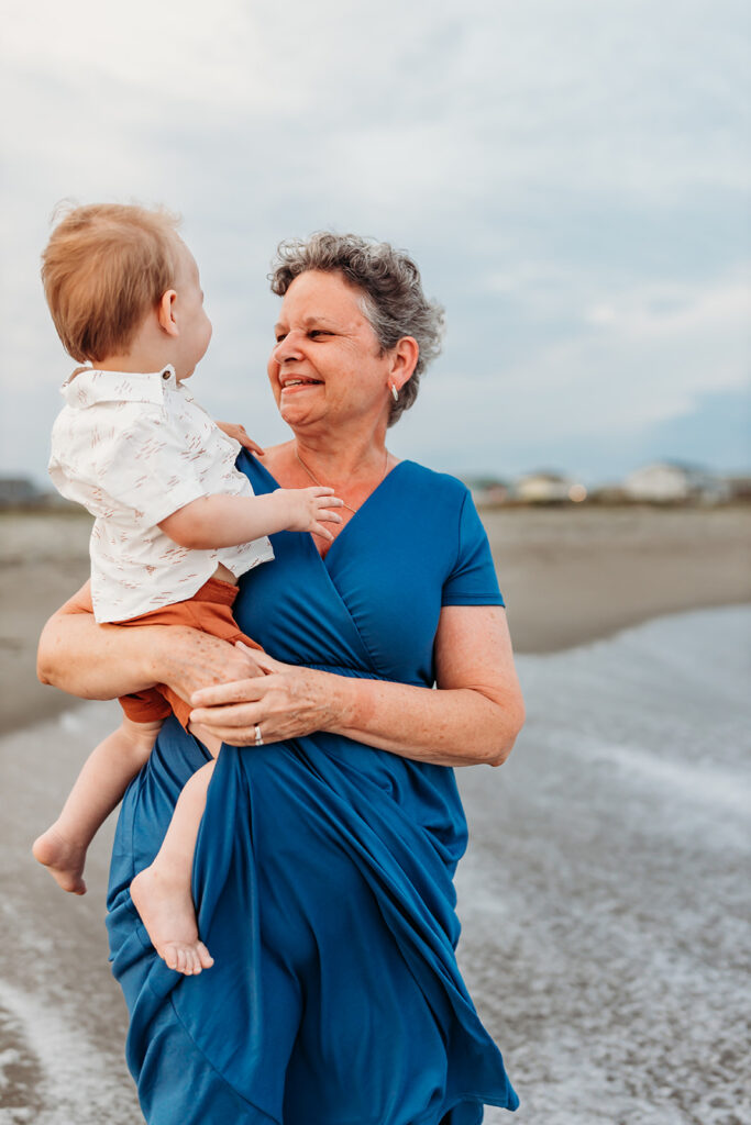 Grandmother on the beach with her toddler grandson in Holden Beach