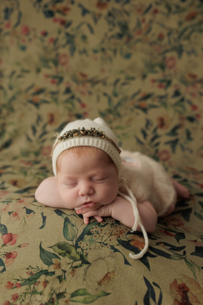 york, pa studio newborn session with baby girl in a soft ivory bonnet sleeping peacefully with her head on her hands 