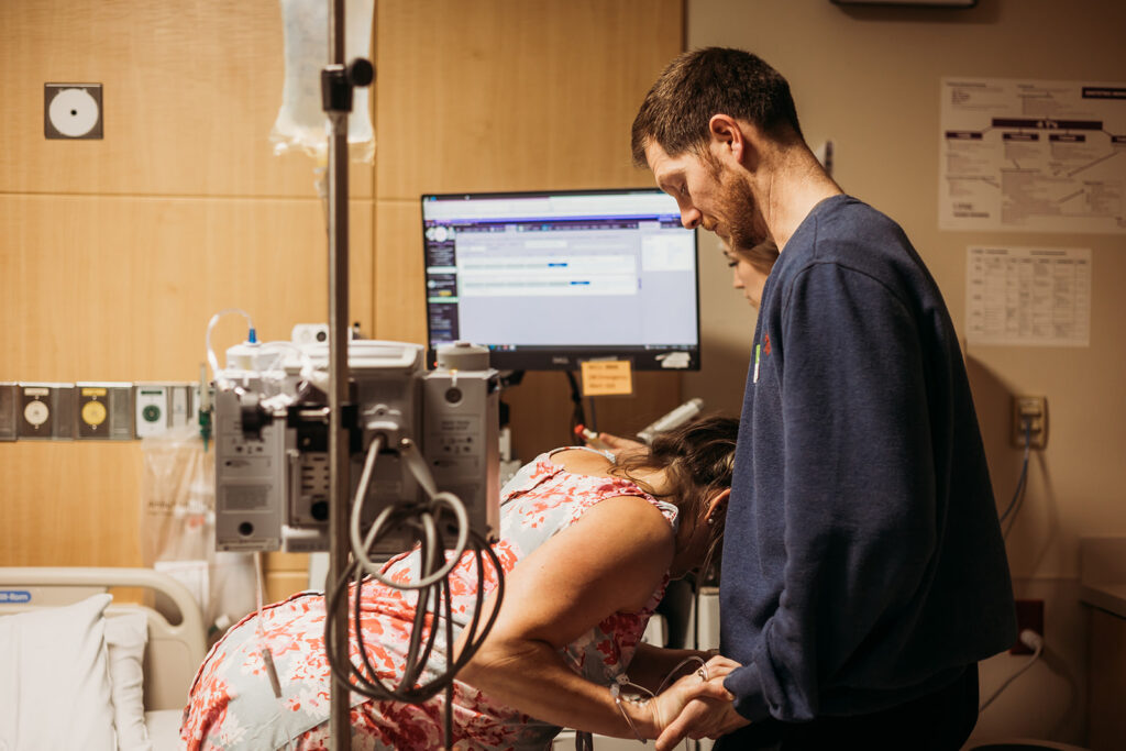 This husband helps support his wife as she stands during a tough contraction during harrisburg pa birth photography 