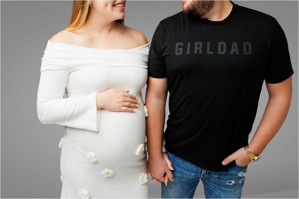 photo of a husband and wife looking at one another the dad to be is wearing a black girl dad tshirt as they expect a newborn baby girl in york pa