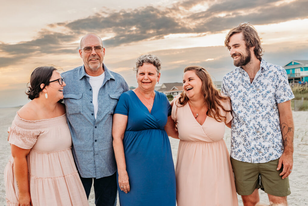Adult children laugh with their mom and dad enjoying their family photo session at Holden Beach