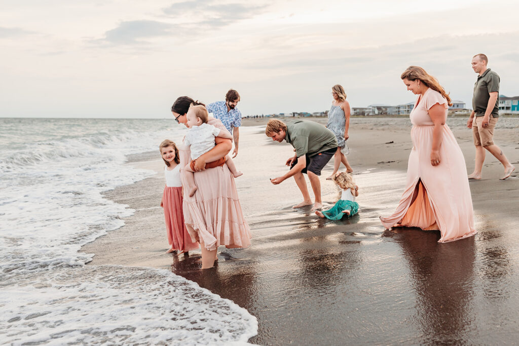 Family gathers together for an extended family session with their Holden Beach photographer at sunset.