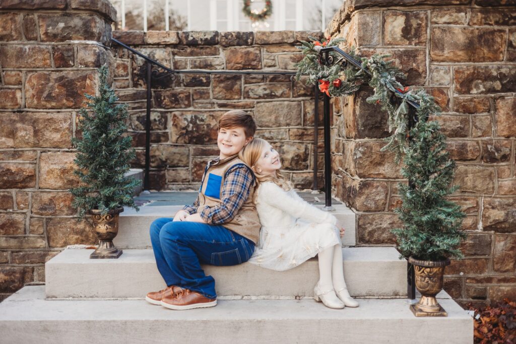 siblings pose back to back on the steps of the beautiful historic shady lane in manchester, pa for christmas card photos