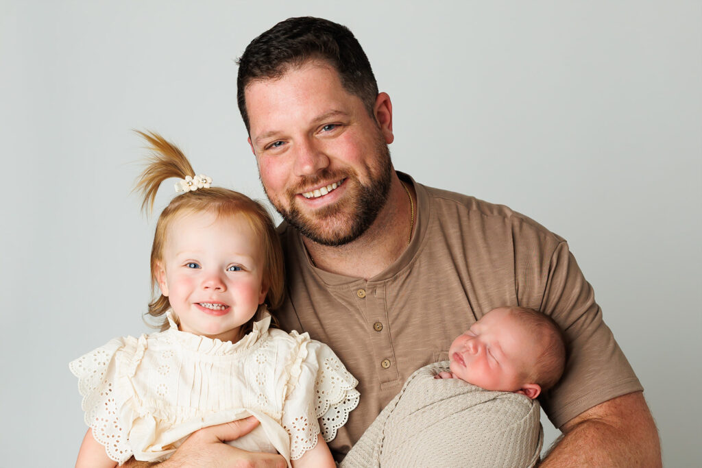 Dad holding newborn in neutral shirt at Hershey PA newborn session
