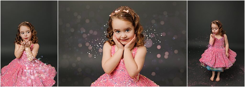 A young girl with curly brown hair wearing a sparkly pink dress plays with glitter in a studio. In the first image, she blows glitter from her hands; in the second, she smiles sweetly with her hands on her cheeks as glitter floats around her; and in the third, she looks down while gently blowing glitter, surrounded by soft bokeh lights and sparkles against a dark backdrop.