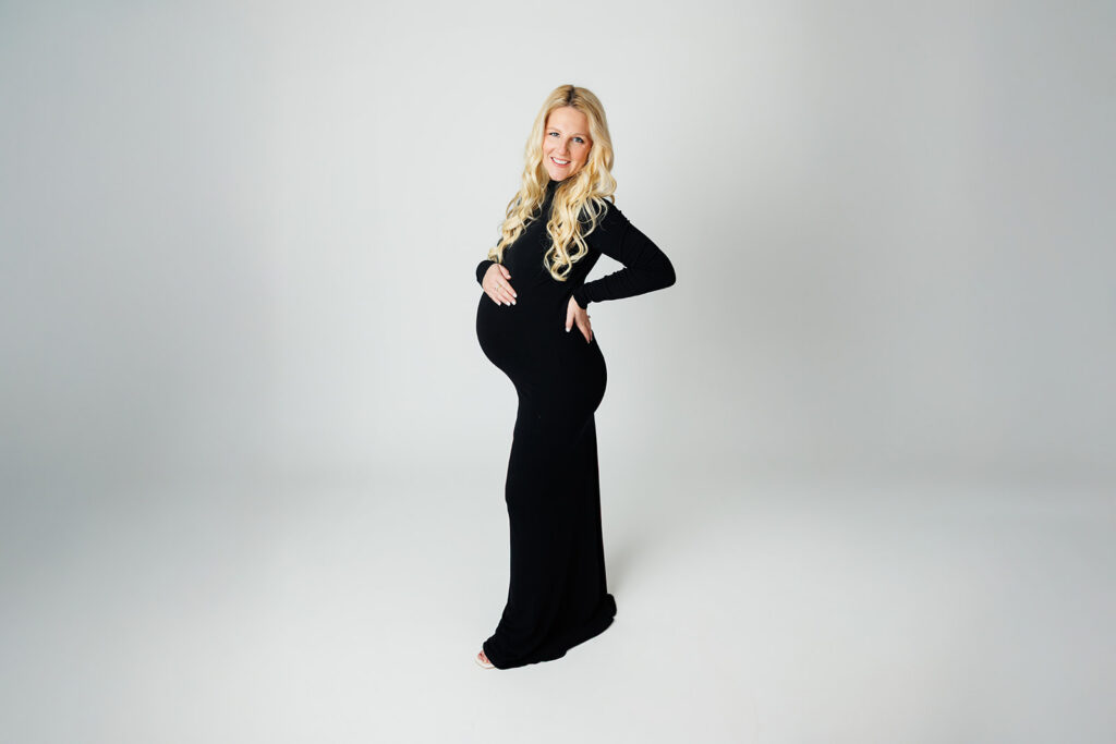 Side profile maternity portrait in black fitted gown photographed in Dover PA studio