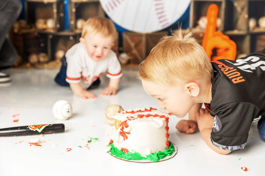 Big brother helping with cake smash during cake smash first birthday session