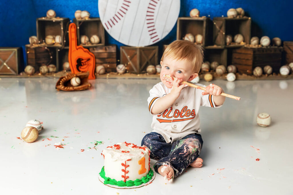One year old baby boy covered in cake during Orioles baseball  themed cake smash 