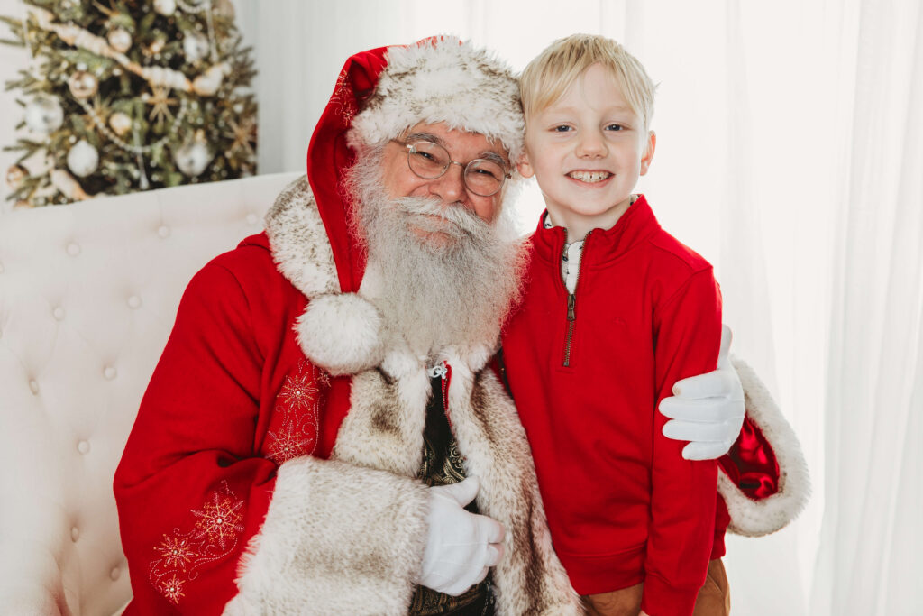 blonde little boy smiling with santa